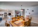 Dining area open to the kitchen, featuring a wooden table, pendant lighting, and neutral decor at 19849 N 33Rd Ave, Phoenix, AZ 85027