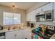 Bright kitchen featuring stainless steel appliances, white cabinets, and a window over the sink at 19849 N 33Rd Ave, Phoenix, AZ 85027