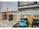 Close-up of a kitchen with a modern microwave, countertop appliances, and electric stove with cookware at 19849 N 33Rd Ave, Phoenix, AZ 85027