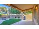 Cozy covered patio with string lights offers views of the well-maintained backyard with artificial turf and BBQ area at 2224 W Olive Way, Chandler, AZ 85248