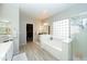 Bright primary bathroom with white cabinets, double sinks, soaking tub, shower, and a view of the walk-in closet at 2224 W Olive Way, Chandler, AZ 85248