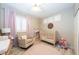 Bedroom with a beige crib, rocker, wood-look tile flooring, and lavender accents at 2224 W Olive Way, Chandler, AZ 85248
