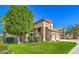 Charming home with a well-manicured lawn, mature trees, and a three-car garage on a sunny day at 2224 W Olive Way, Chandler, AZ 85248