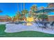 Resort-style pool area with a rock feature, lush landscaping, and dining set for outdoor entertaining at 2224 W Olive Way, Chandler, AZ 85248