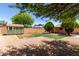 Large, private backyard with a storage shed, lush trees, desert landscaping, and partial grass at 2302 E Monte Cristo Ave, Phoenix, AZ 85022