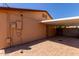 View of the carport area with brick flooring, accessed through a metal door, and featuring an exterior light at 2302 E Monte Cristo Ave, Phoenix, AZ 85022