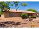 Side exterior elevation featuring desert landscaping, lush green shrubbery, and painted stucco at 2302 E Monte Cristo Ave, Phoenix, AZ 85022