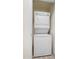 A stacked, white washer and dryer set with top mounted controls stands ready in this laundry closet at 2401 E Rio Salado Pkwy # 1055, Tempe, AZ 85288