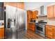 Bright kitchen featuring stainless steel appliances, wood cabinetry, and tile backsplash at 2715 E Edgemont Ave, Phoenix, AZ 85008