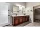 Bathroom featuring double sinks, wood cabinets, marble countertop, modern fixtures, and a tile floor at 3028 W Parkside Ln, Phoenix, AZ 85027