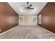 Neutral carpeted bedroom with a ceiling fan, plantation shutters, and accent wall at 3028 W Parkside Ln, Phoenix, AZ 85027