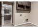Neutral laundry room with brown cabinets, tile floors, and view of kitchen at 3028 W Parkside Ln, Phoenix, AZ 85027
