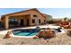 Backyard features freeform pool with rock accents and view of house at 3028 W Parkside Ln, Phoenix, AZ 85027