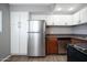 Bright kitchen offering stainless steel refrigerator and dishwasher with white cabinets at 3230 E Pinchot Ave # 32, Phoenix, AZ 85018