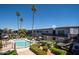 Aerial view of community pool and apartments with balcony and palm trees on a sunny day at 3230 E Pinchot Ave # 32, Phoenix, AZ 85018