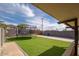 Backyard view of an artificial turf lawn, a trampoline, block fence and covered patio at 327 E Monte Way, Phoenix, AZ 85042