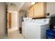 Laundry room with washer, dryer, tile floors, and built in cabinets at 327 E Monte Way, Phoenix, AZ 85042