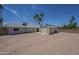 A spacious backyard featuring a storage shed, covered patio, palm trees, and gravel landscaping at 3362 E Carol Ave, Mesa, AZ 85204