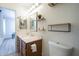 A full bathroom with an updated vanity and floating shelves to keep things organized and accessible at 3362 E Carol Ave, Mesa, AZ 85204