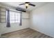 Simple bedroom with wood flooring, window with blinds, and built-in shelving units for storage at 3362 E Carol Ave, Mesa, AZ 85204