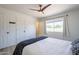 Bright bedroom featuring wood-look floors, a ceiling fan, and a large window for natural light at 3362 E Carol Ave, Mesa, AZ 85204