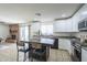 Open-concept kitchen showcasing white cabinets, stainless steel appliances and an island with bar seating next to a fireplace at 3362 E Carol Ave, Mesa, AZ 85204