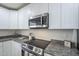 Close-up of the kitchen featuring a modern stove, white cabinets, and elegant countertops at 3362 E Carol Ave, Mesa, AZ 85204