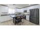 Stylish kitchen boasts white cabinets, sleek countertops, stainless steel appliances and a central island with bar seating at 3362 E Carol Ave, Mesa, AZ 85204