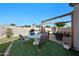 Outdoor dining and gathering space includes a charming pergola, lush grass, and comfortable seating at 36515 N Takota Trl, San Tan Valley, AZ 85140