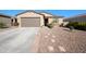 Inviting single-Gathering home with desert landscaping, a spacious driveway, and a welcoming covered entrance, under a clear blue sky at 36515 N Takota Trl, San Tan Valley, AZ 85140