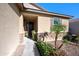 Welcoming front porch features a dark wood door, desert landscaping, and stone accents, enhanced by a clear, sunny day at 36515 N Takota Trl, San Tan Valley, AZ 85140