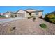 Charming single-story home featuring desert landscaping and a two-car garage, bathed in bright sunlight against a clear blue sky at 36515 N Takota Trl, San Tan Valley, AZ 85140