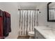 Charming bathroom with a gray vanity, marble countertop, and tub shower with modern shower curtain at 3765 W Wood Dr, Phoenix, AZ 85029