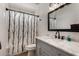 Charming bathroom with a white vanity, marble countertop, and tub shower with modern shower curtain at 3765 W Wood Dr, Phoenix, AZ 85029