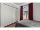 Bedroom with a bed, wood floors, and closet, and window with red curtains at 3765 W Wood Dr, Phoenix, AZ 85029