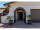 Beautiful front porch area with a textured brick archway and decorative potted plants at 3765 W Wood Dr, Phoenix, AZ 85029