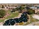 Expansive aerial view showcasing a community with a pool, pond, and lush green spaces, highlighting a tranquil setting at 42311 W Good Vibrations Ln, Maricopa, AZ 85138