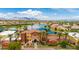 Aerial view of the community clubhouse with lake, swimming pool and the mountains in the background at 42311 W Good Vibrations Ln, Maricopa, AZ 85138