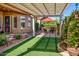 Serene backyard with a pergola-covered seating area, lush greenery, and a charming water fountain at 42311 W Good Vibrations Ln, Maricopa, AZ 85138