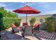 Cozy backyard patio with comfortable seating and a red umbrella, ideal for relaxing outdoors at 42311 W Good Vibrations Ln, Maricopa, AZ 85138