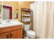 Bright bathroom with a white vanity, a shelf for linens, and a shower with a neutral-colored curtain at 42311 W Good Vibrations Ln, Maricopa, AZ 85138