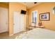 Inviting bedroom with a sliding closet, a TV, plantation shutters, and a cozy chair at 42311 W Good Vibrations Ln, Maricopa, AZ 85138