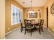 Dining room with round table, four chairs, chandelier, carpet, and window with shutters at 42311 W Good Vibrations Ln, Maricopa, AZ 85138