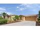 Well-maintained home exterior with desert landscaping and a spacious driveway leading to a two-car garage at 42311 W Good Vibrations Ln, Maricopa, AZ 85138