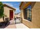 Charming front entrance with a red door and gated courtyard, providing a private and inviting entry at 42311 W Good Vibrations Ln, Maricopa, AZ 85138