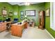 Spacious home office with dark green walls, built-in desk, ample storage, and a ceiling fan at 42311 W Good Vibrations Ln, Maricopa, AZ 85138