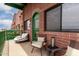 A brick condo balcony features outdoor seating, a green door, and a view of the city at 424 S 2Nd St # 306, Phoenix, AZ 85004
