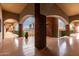 Bright hallway overlooking the city with arched walkways, brown brick walls, and potted plants at 424 S 2Nd St # 306, Phoenix, AZ 85004