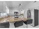 Kitchen features an island with bar stools, stainless appliances, and granite countertops, great for cooking at 4519 E Amberwood Dr, Phoenix, AZ 85048