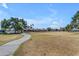 Serene community park with a curving walkway through an open grassy space, surrounded by mature trees at 4519 E Amberwood Dr, Phoenix, AZ 85048